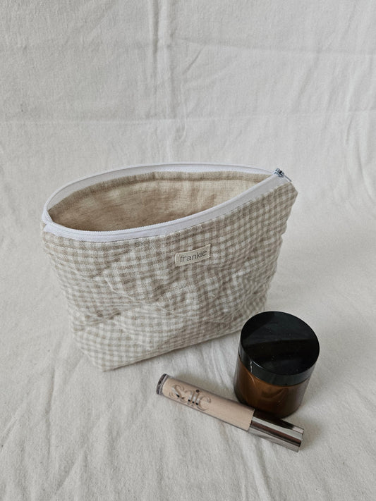 Cosmetic bag with a jar and tube on a textured surface